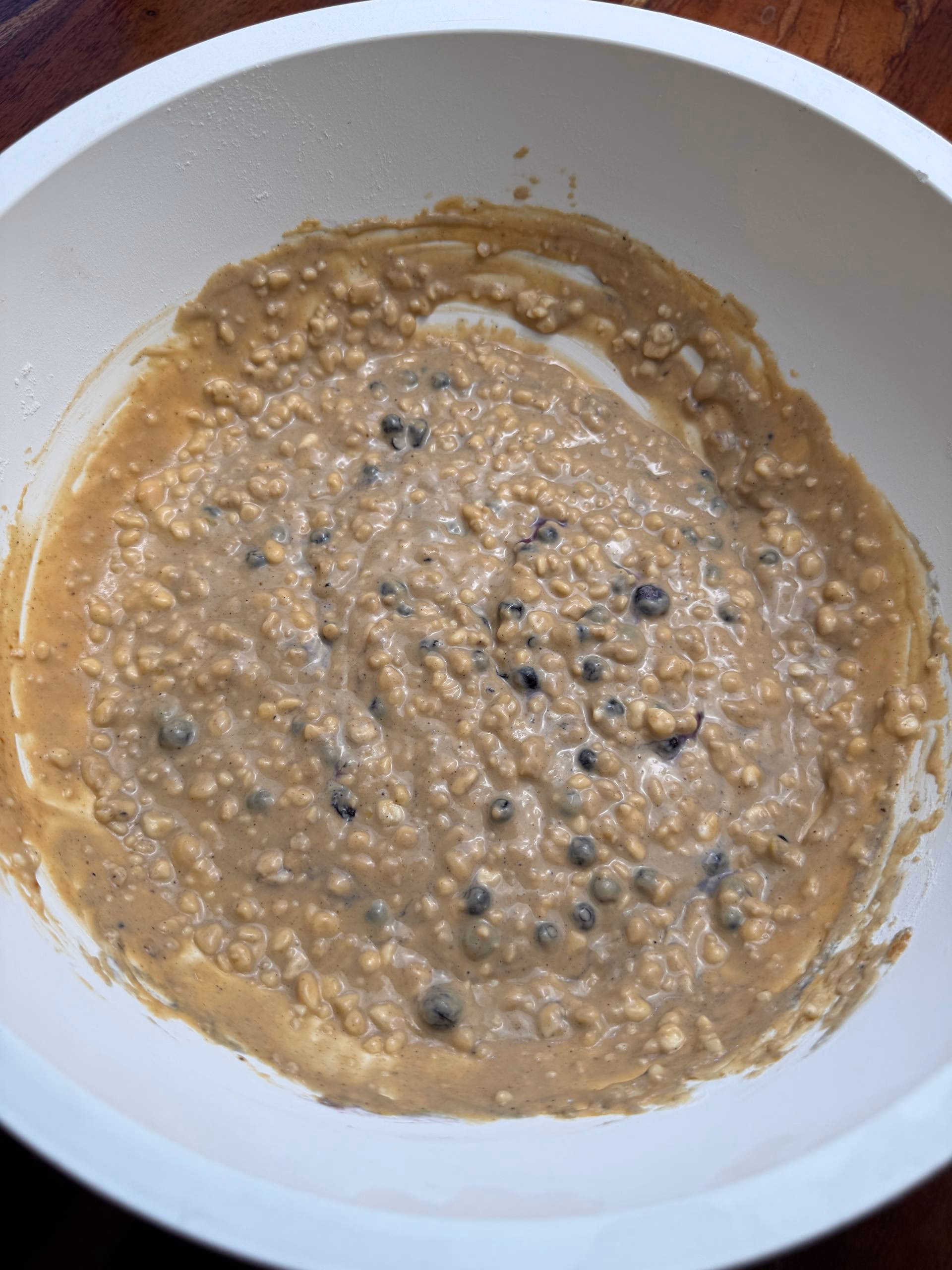 Angeruehrter Pancake-Teig mit dunklen Beerenstuecken in einer Schuessel
