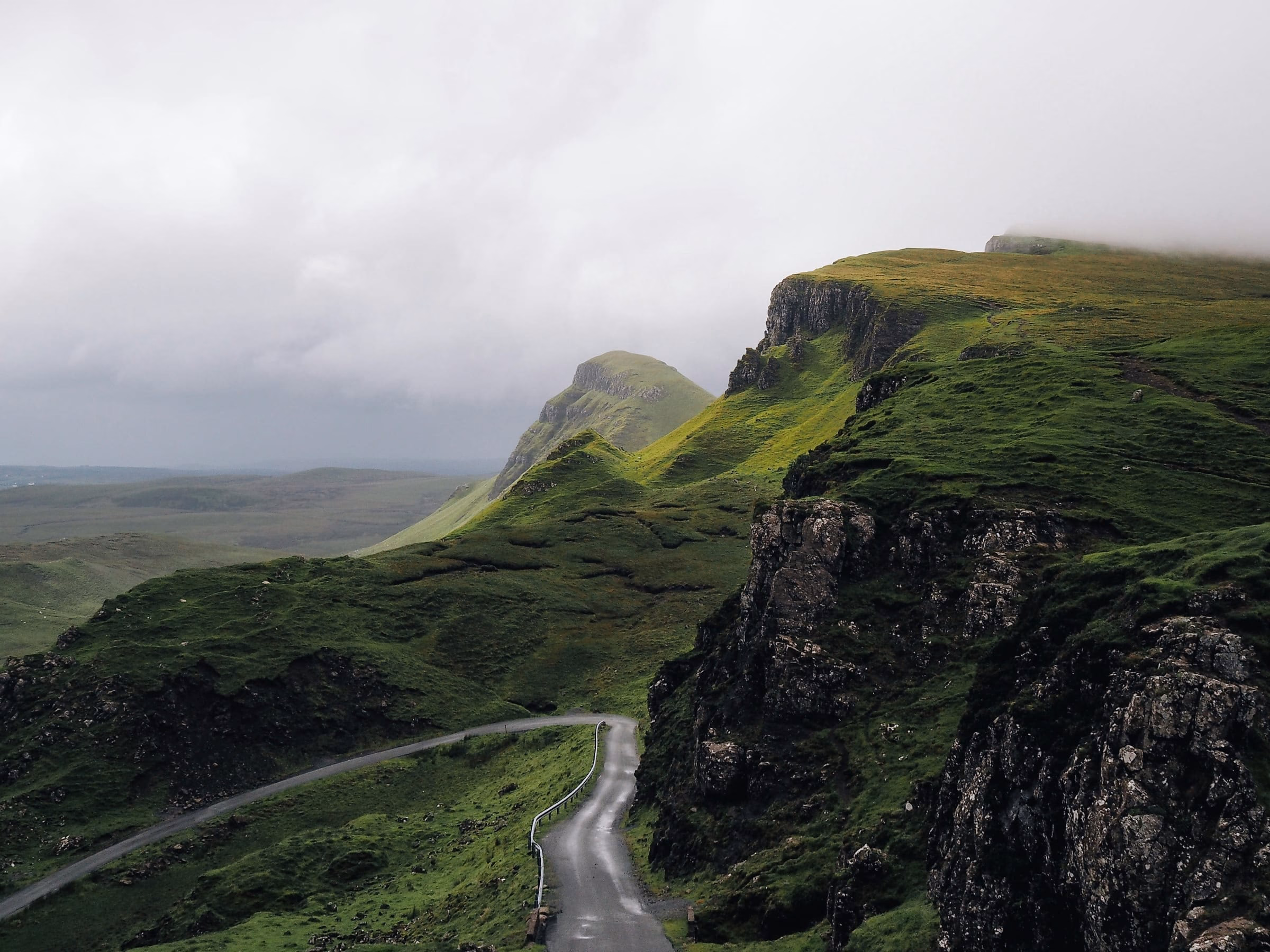 Kurvige Strasse durch eine gruene Berglandschaft