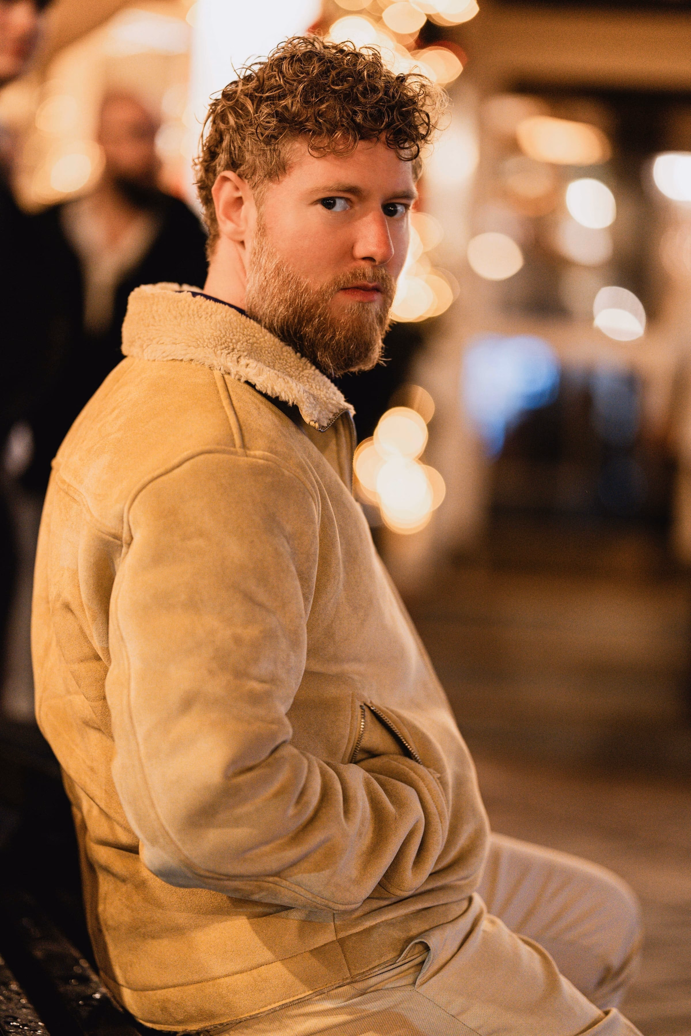 Benjamin Weidig in beiger Jacke, ueber die Schulter blickend